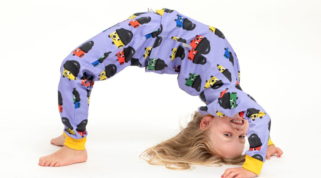 Child wearing pyjamas bending over backwards in professional photography studio at a Commercial Product Photography shoot for childrens clothing company The Little One