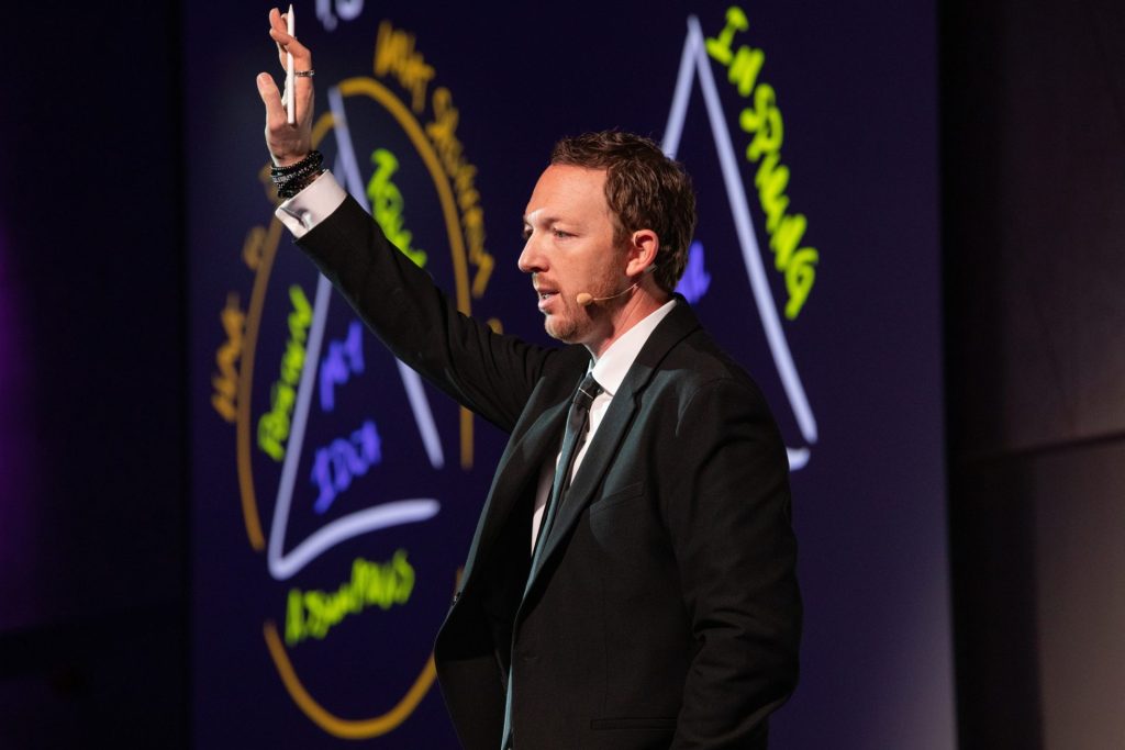 Male speaker on stage at live event Salon Owners Summit 2023 in Dublin Royal Convention Centre Dublin Event Photographer